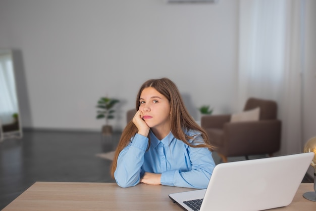 Bored young girl taking a break from online classes