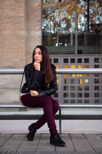 Bored young woman waiting at the bus stop