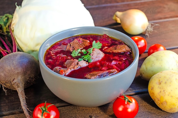 Borscht soep met groenten en vlees op een houten tafel