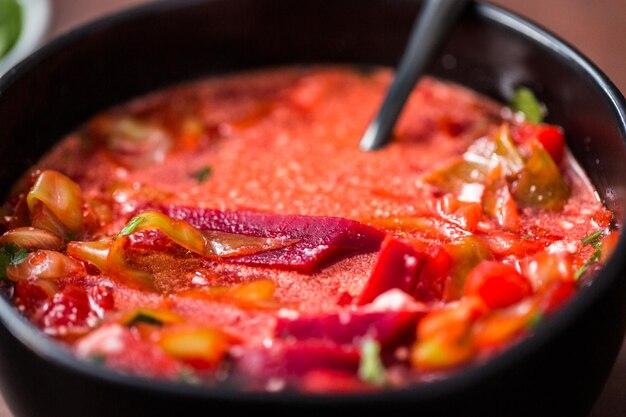 Borscht soup in a black bowl for dinner.