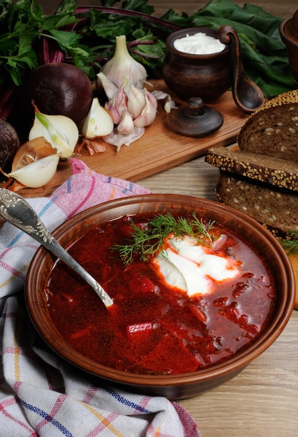 Foto borschtgroente bietensoep op tafel met sneetjes roggegraanbrood knoflook en kruiden