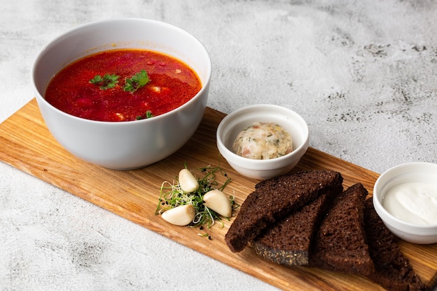 Borsjt bortsch borsjt borsjt Soep geassocieerd met de keuken van Oost- en Centraal-Europa, met name Oekraïne Geserveerd op een houten bord met roggebrood, zure room, stukjes knoflook en reuzel