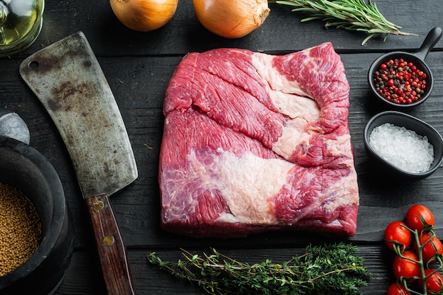 Borst plat gesneden, rauwe runderborst vlees set, met ingrediënten voor het roken van barbecue, pastrami, genezen, op zwarte houten tafel achtergrond