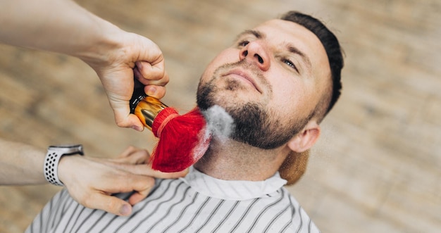 Borstel voor het scheren van baard samen met kom wazige achtergrond van kapsalon mannen kapperszaak