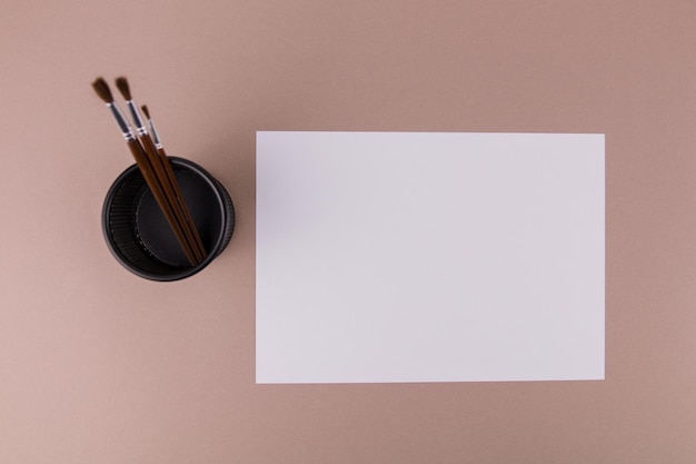 Borstels om op tafel te schilderen bij een wit vel papier