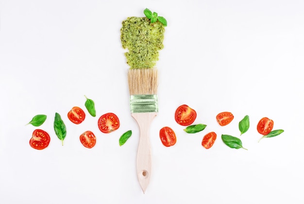 Borstelstreek pestosaus met basilicumblaadjes en tomaten