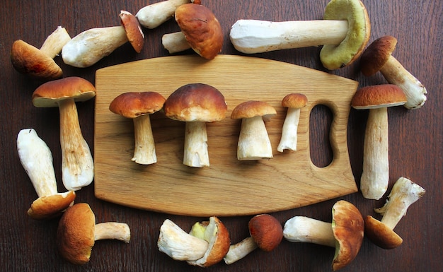 Bos boletus paddestoelen op een rustieke houten achtergrond en een houten snijplank