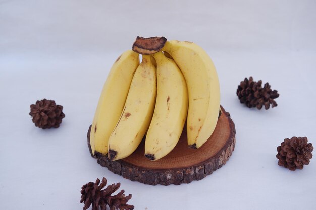 Bos van bananen op een houten standaard op een witte achtergrond