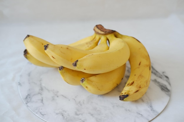 Bos van bananen op een witte marmeren tafel Selectieve aandacht