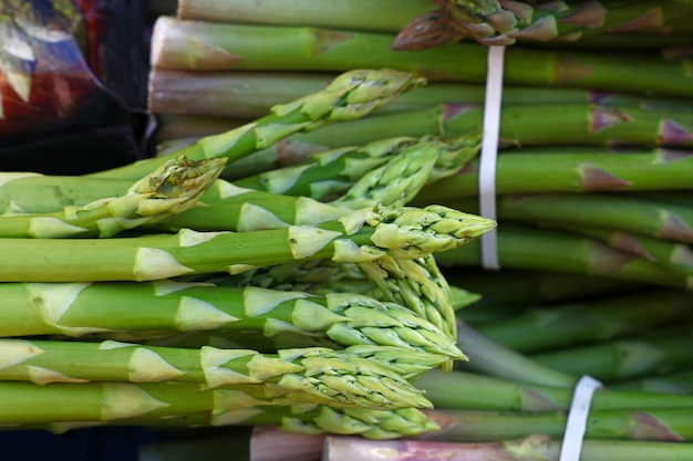 Bos van verse groene asperges schiet op de kleinhandelsmarktvertoning, close-up, hoge hoekmening