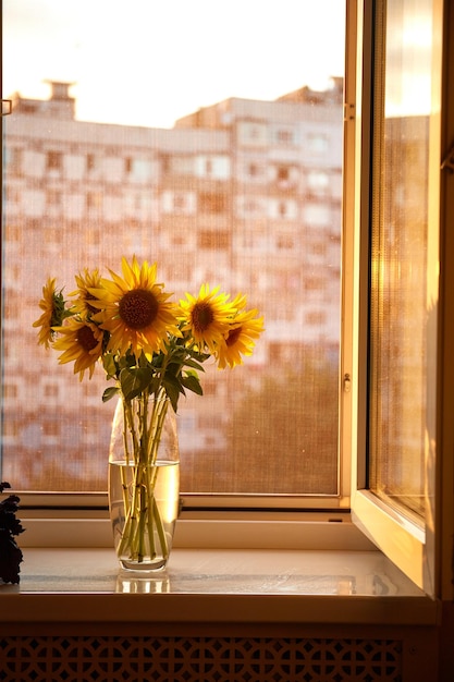 Bos zonnebloemen in vaas op vensterbank