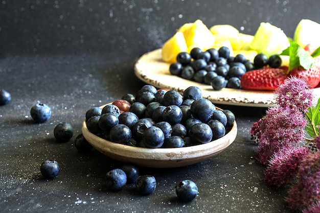 Bosbessen en andere soorten fruit op donkere achtergrond