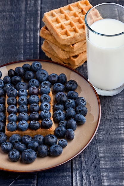 Bosbessen en wafels op plaat met melkglas