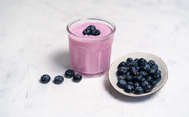 bosbessen milkshake met bosbessen en kom op witte tafel