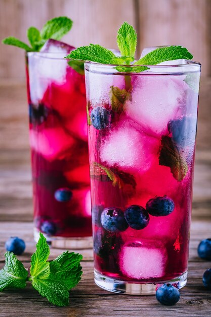 Bosbessenijslimonade met munt in glazen op houten achtergrond