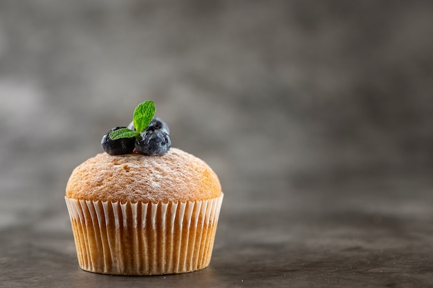 Bosbessenmuffin op grijs. Zijaanzicht.