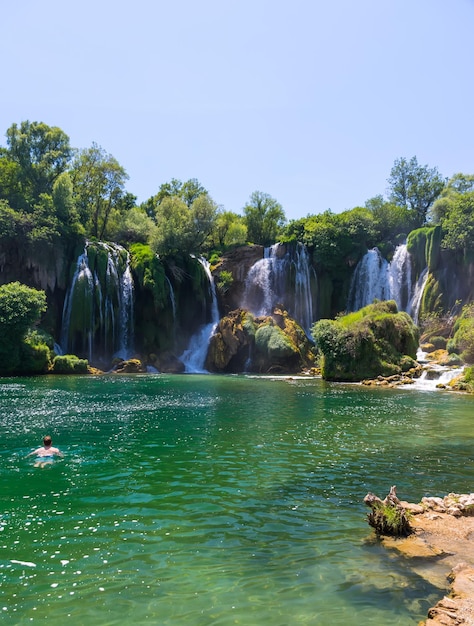 BOSNIA AND HERZEGOVINA LYUBUSHKI. tourists rest and swim in the picturesque waterfall