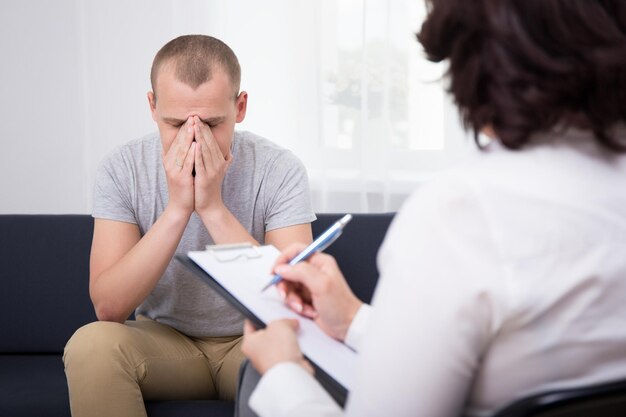 Boss dismissing an employee - young sad man in office