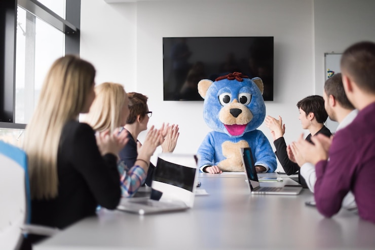 फोटो boss dresed as teddy bear having fun with bussines people in modern corporate office