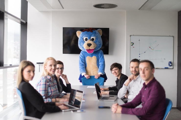 फोटो boss dresed as teddy bear having fun with bussines people in modern corporate office
