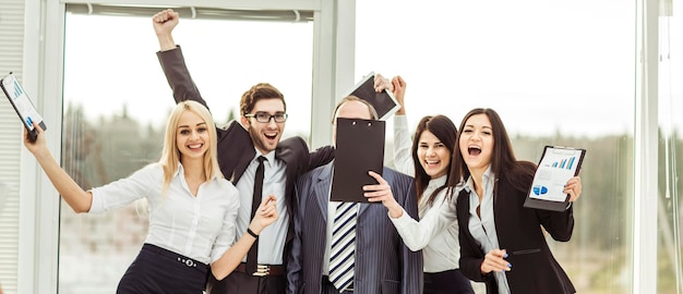 Boss and happy business team rejoice after signing a lucrative financial contract