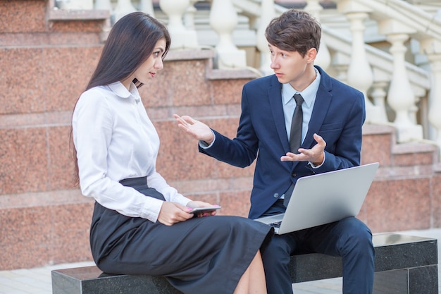 Boss and his assistant discussing their work outdoors