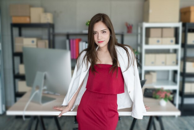 Boss is wearing red dress and white suit. she is confident working woman and beautiful