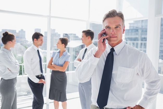 Boss on the phone standing in a modern office