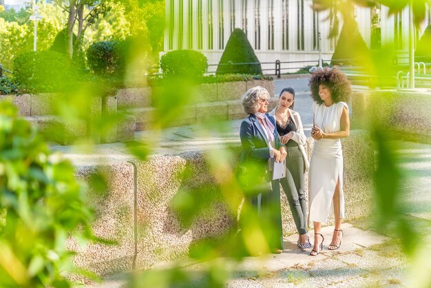 Boss and two female employees chatting happily after work