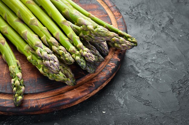 Bossen verse groene asperges op een zwarte achtergrond Gezonde voeding Bovenaanzicht Vrije ruimte voor uw tekst