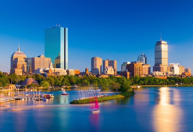Фото Бостон на фоне линии горизонта. городской пейзаж бэк-бэй бостон. небоскребы и офисные здания отражаются в воде реки чарльз.