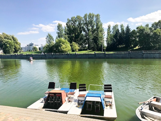 Boten en catamarans op een vijvermeer in een rivierkanaal met groen bloemrijk water liggen afgemeerd