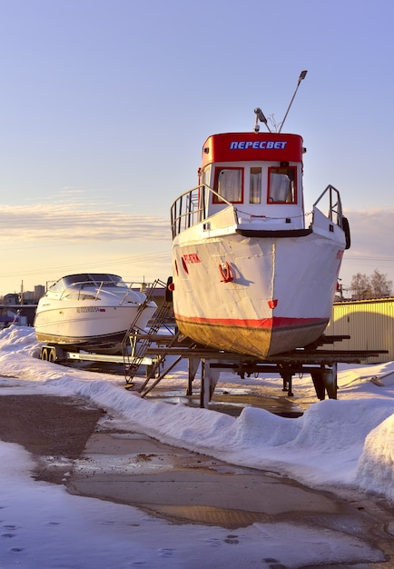 Boten en jachten in de winter Rivierboot winters aan de kust tussen de sneeuwbanken