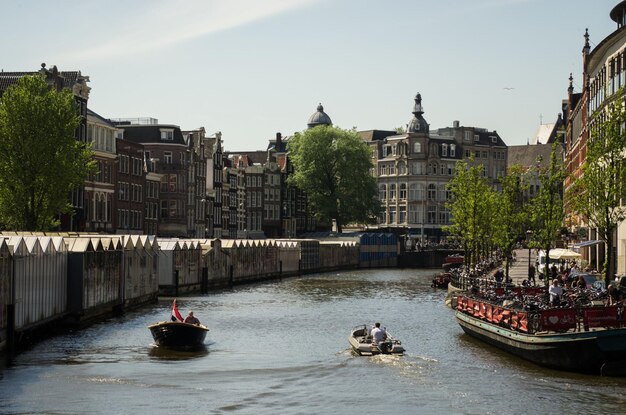 Foto boten in de rivier met gebouwen op de achtergrond