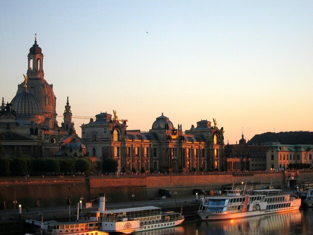 Foto boten in het kanaal bij dresden frauenkirche tegen de hemel bij zonsondergang