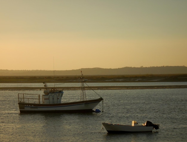 Boten op de kust bij zonsondergang