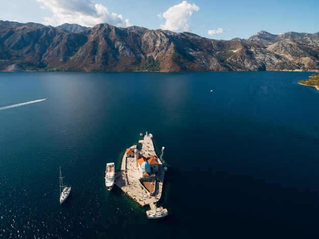 Boten zijn afgemeerd op het eiland gospa od skrpjela in de baai van kotor montenegro