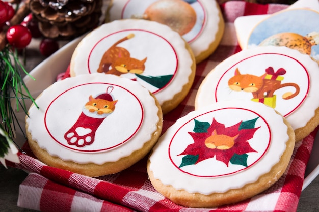 Boterkoekjes van Kerstmis die met Kerstmisgrafiek worden verfraaid, op houten lijst Dichte omhooggaand