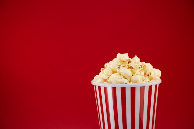 Boterpopcorn in een rode popcornkop, snack in huis of bioscoop