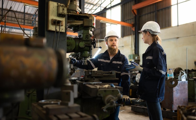 Both of mechanical engineers are checking the working condition of an old machine