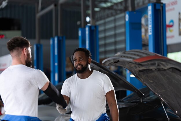 Both of professional auto mechanic working together in auto repair shopxA