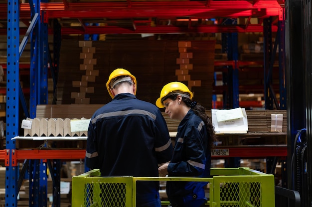 Foto entrambi i dipendenti del magazzino lavorano insieme in un grande magazzino di carta utilizzando un tablet.