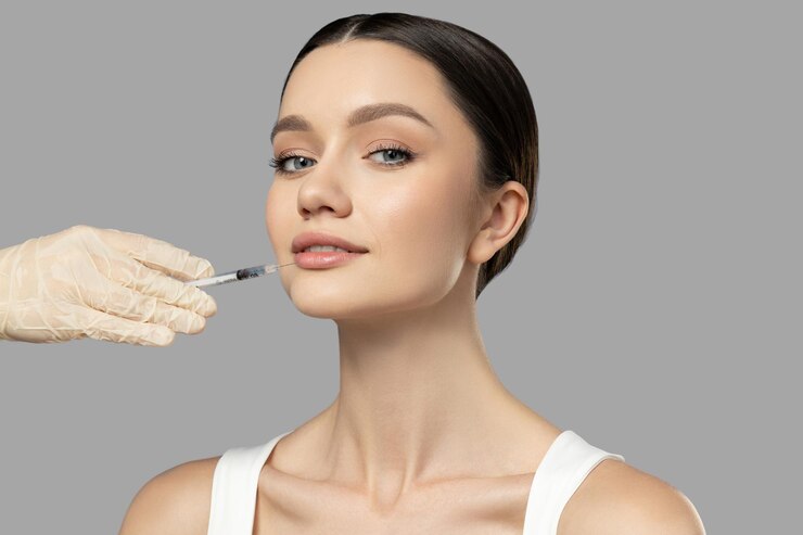 Photo botox skin care a girl gets a botox injection on a light background