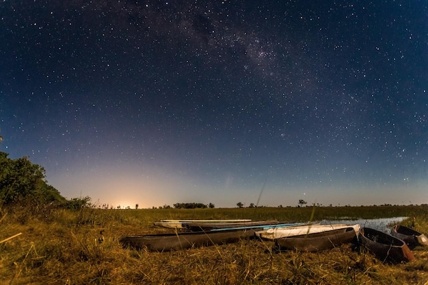 Botswanian local mokoro boats under the starlight sky on the shore of delta Okavango river Botswana