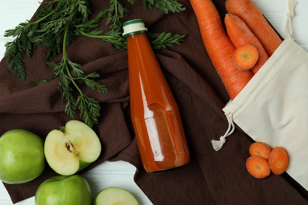 Foto bottiglia di succo di mela carota e ingredienti, vista dall'alto