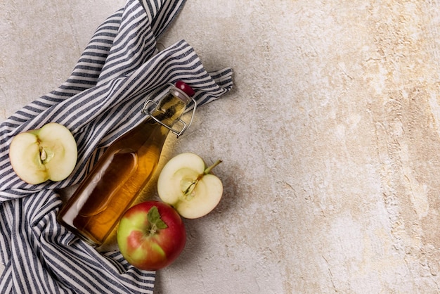 Bottle of Apple Cider Vinegar or Apple Juice with a Fresh Apple Napkin Concrete Background T