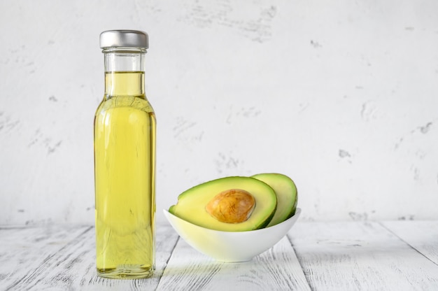 Photo bottle of avocado oil with fresh avocado