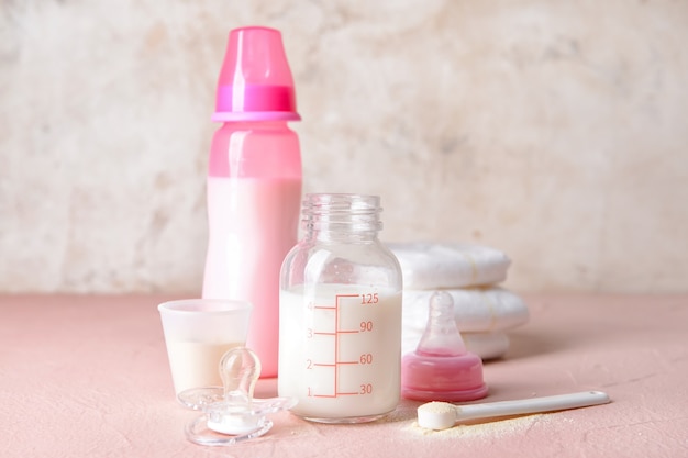 Бутылка детской молочной смеси и аксессуары на столе