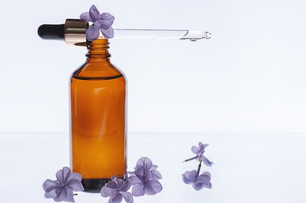 Bottle of beauty oil with lilac flowers