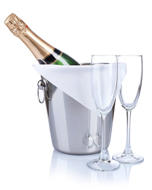 Bottle of champagne in pail and empty glasses, isolated on white